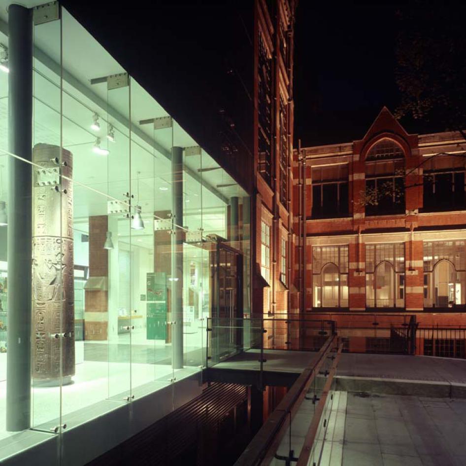 Illuminated museum entrance with glass facade at night